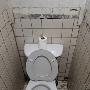 a toilet in a dirty bathroom