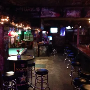 a pool table and bar with stools