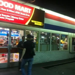 a man standing in front of a food mart