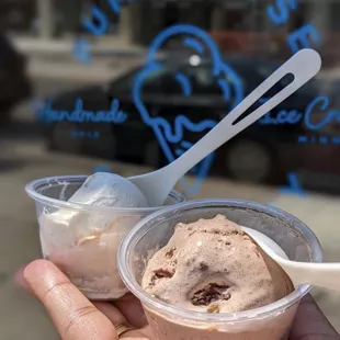 a hand holding a cup of ice cream