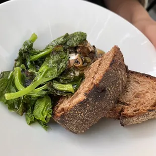 a plate of food with bread and greens