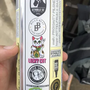 a hand holding a can of beer