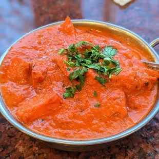 a bowl of indian food with bread