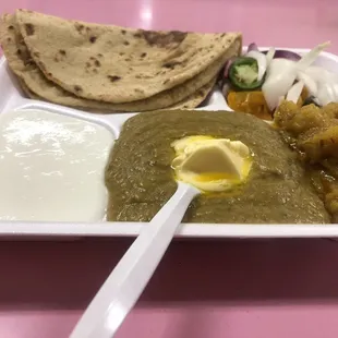 4 Chappatis, onions-jalapeños salad, lemon pickle, Turnipand potatoe dry curries, Saag and plain yoghurt.