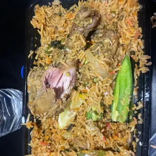 a plate of rice with meat and vegetables