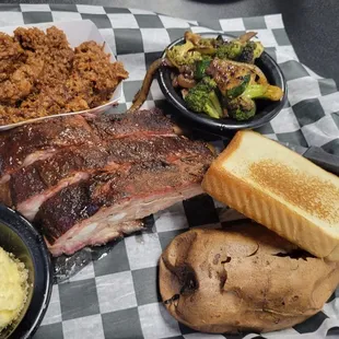 ows a plate of ribs, potatoes, and a side dish