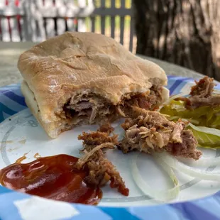 a pulled pork sandwich on a paper plate