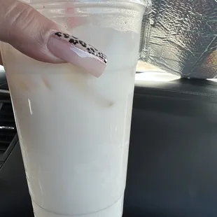 a person holding a drink in a plastic cup