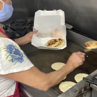 a woman in a face mask making pita bread