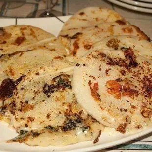 a plate of pupusas with cheese and spinach