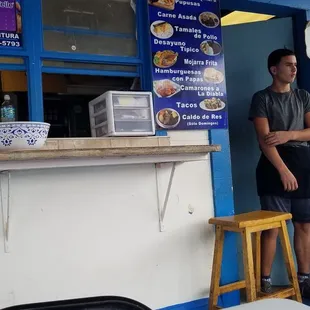 a man standing in front of a food stand