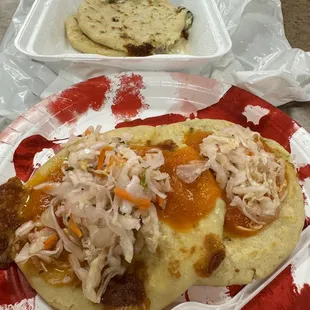 Pupusa calabasa and pupusa Chicharron con Queso topped with sauce and curtido. (12/27/2023)