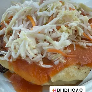 Pupusas properly dressed with tomato sauce and Curtido