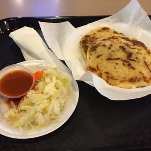 Two Beef pupusa with bean and cheese with condiments (mild hot sauce, and pickled cabbage and carrots)