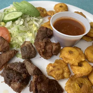 Plantains with pork rind with sweet tomatoes sauce and salad