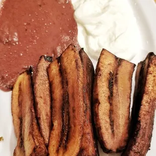 Fried plantains with refried beans and cream