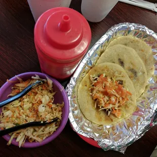 Three pupusas for $6. One of the pupusas here is pictured dressed with slaw and hot sauce. Cheese, pork, and bean fillings.