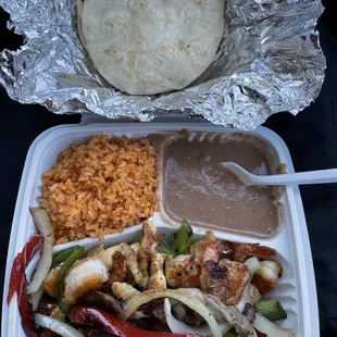 a plate of food with rice, meat, and vegetables