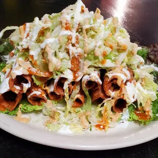 Flautas  10 fried chicken tacos with lettuce sour cream cheese and chipotle dressing.