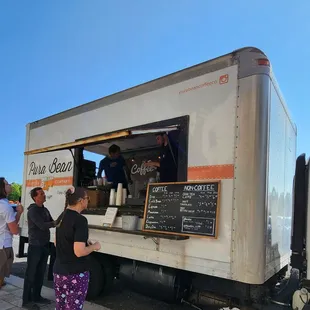 a group of people standing around a food truck