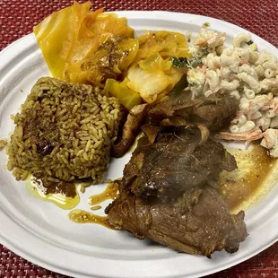 Jerk chicken with Jamaican rice and beans and cabbage with macaroni salad.