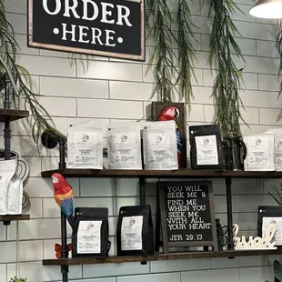 a shelf of coffee beans and a sign that says order here