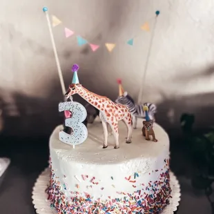 a birthday cake with a giraffe and a zebra