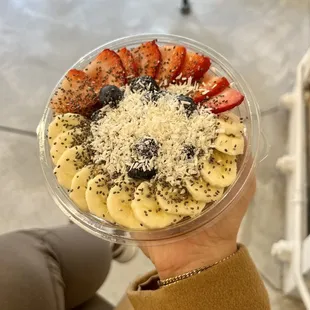 a person holding a bowl of fruit
