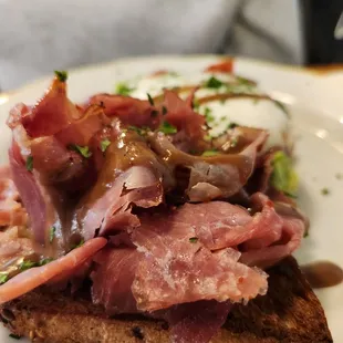 a piece of toast with meat and vegetables