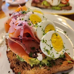 a plate of food with eggs, ham, and avocado