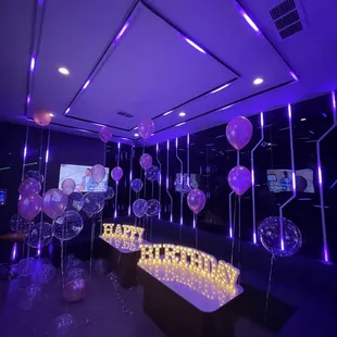 a room filled with balloons and lights