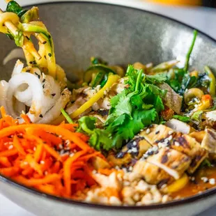 Korean Zoodle Bowl Zucchini and yellow squash noodle, spinach, cashew, PureBlend slaw, cilantro, carrot, gochujang sauce, cashew, daikon rad