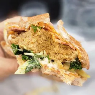 a hand holding a sandwich