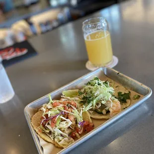 a tray of tacos and a glass of beer