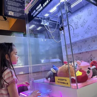 a little girl looking at stuffed animals