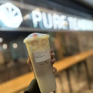 a hand holding a cup of iced coffee