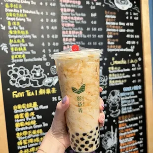 a hand holding a cup of bubble tea