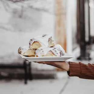 a person holding a plate of pastries