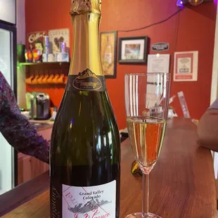 a bottle of champagne and a glass of wine