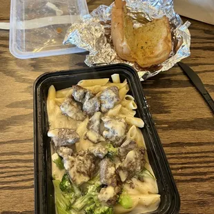 Alfredo steak and broccoli pasta w some garlic bread. In a to go plate