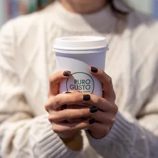 a woman holding a cup of coffee
