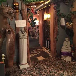 a hallway with a statue of a dragon and a statue of a man