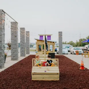 a play area with a wooden play structure