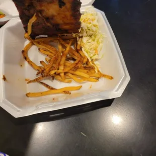 a person taking a piece of food out of a styrofoam container