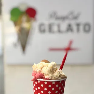 a hand holding a cup of gelato