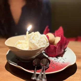 a bowl of ice cream with a lit candle