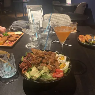 Chicken Cobb salad with Porn Star martini -- front and center.  Falafel to the left and empanadas to the right.