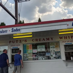 a couple of people standing in front of the ice cream shop