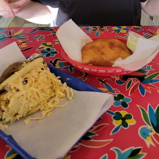 Arepa with chicken salad, topped with gouda cheese, and chicken empanadas