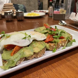 a plate of avocado toast with an egg on top